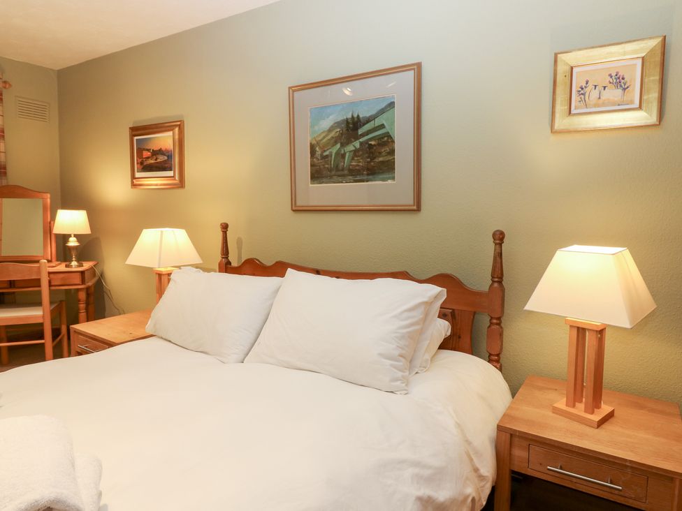 A bedroom with a bed and a mirror at 1 The Cross Dunkeld