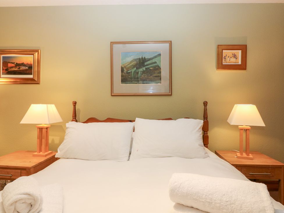 A bedroom with a bed and lamps at 1 The Cross in Dunkeld