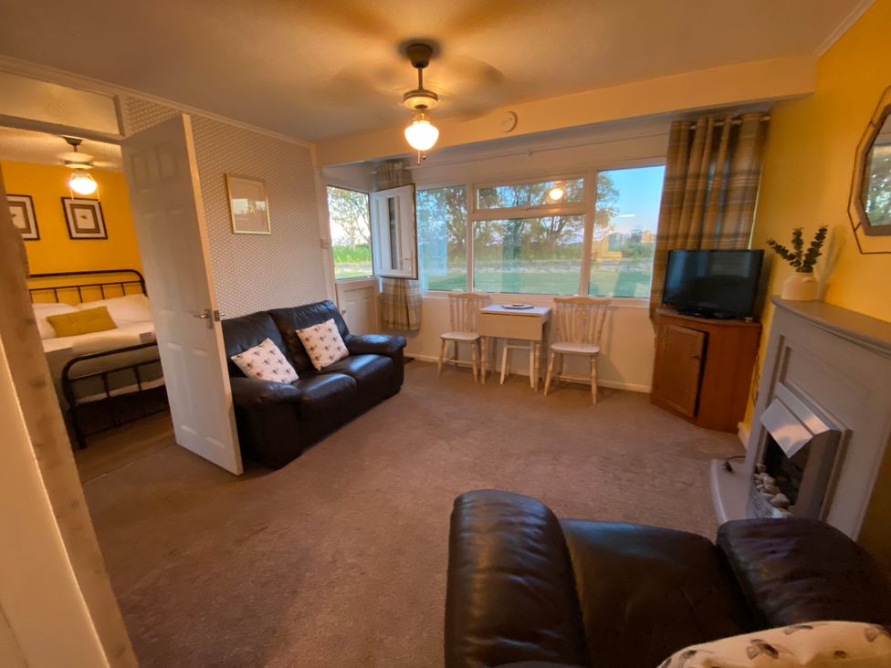 A living room with a sofa, table and chairs at 246 California Road, California, Norfolk