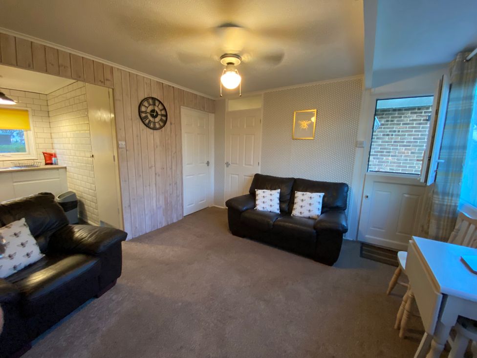 A living room with a sofa, armchair and clock at 246 California Road, California, Norfolk