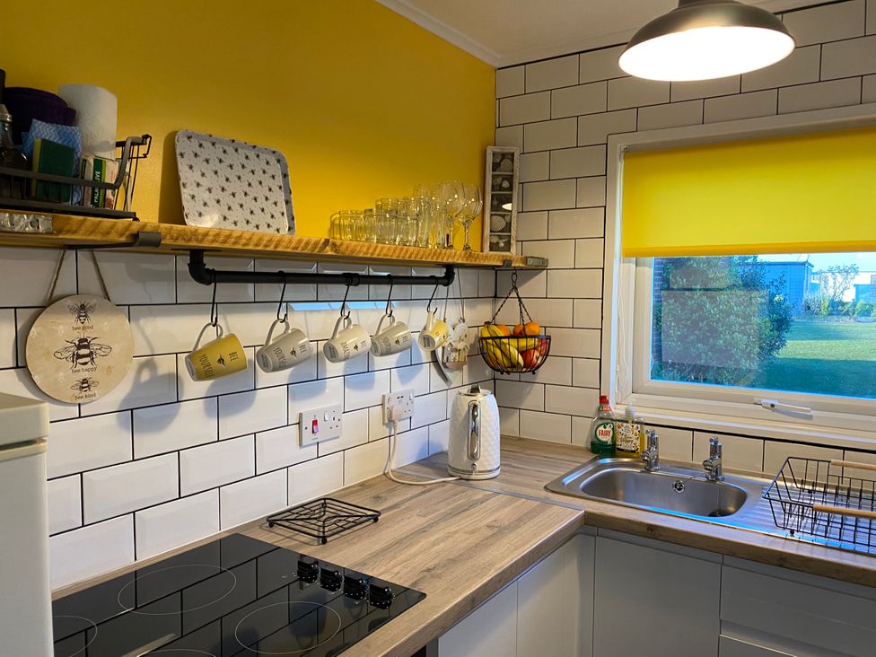 A kitchen with utensils on shelves and a window view at 246 California Road, California, Norfolk