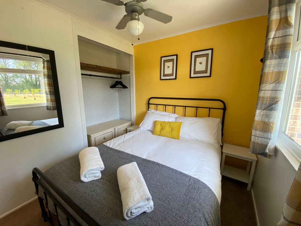 A bedroom with a bed and mirror at 246 California Road, California, Norfolk