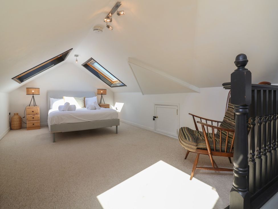 A bedroom with a bed and chair at Auverne Poundstock near Widemouth Bay