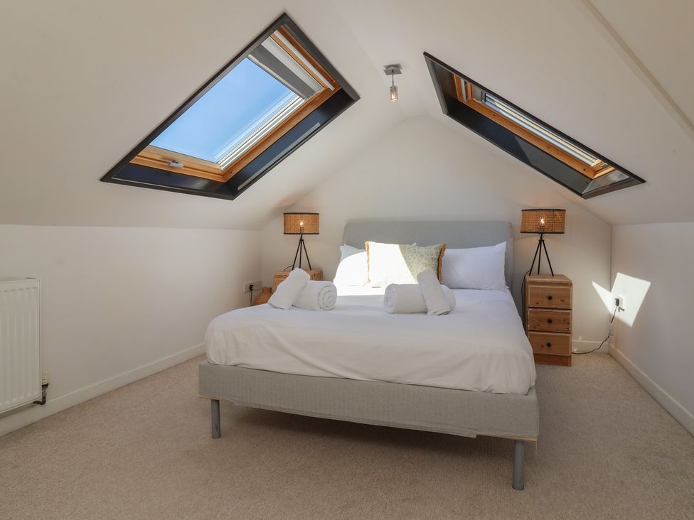 A bedroom with a bed and bedside lamps at Auverne Poundstock near Widemouth Bay