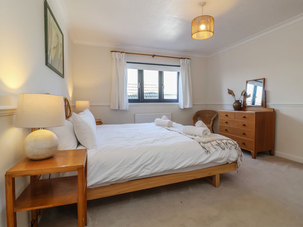 A bedroom with a bed and dresser at Auverne Poundstock near Widemouth Bay