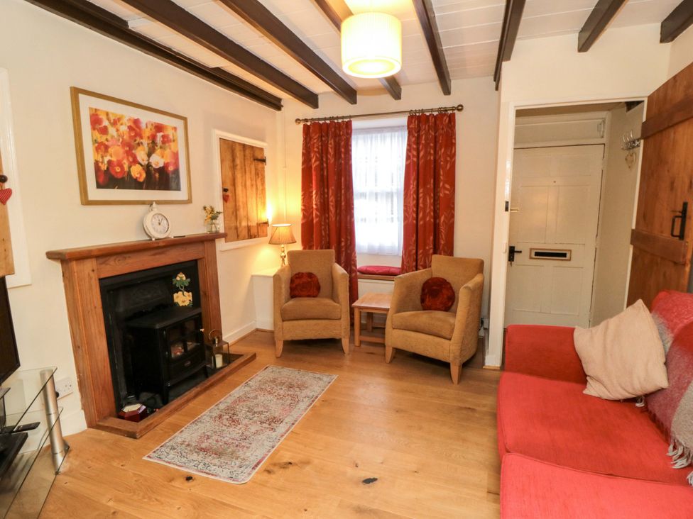 A living room with a fireplace and armchairs at Beacon Cottage in Pickering