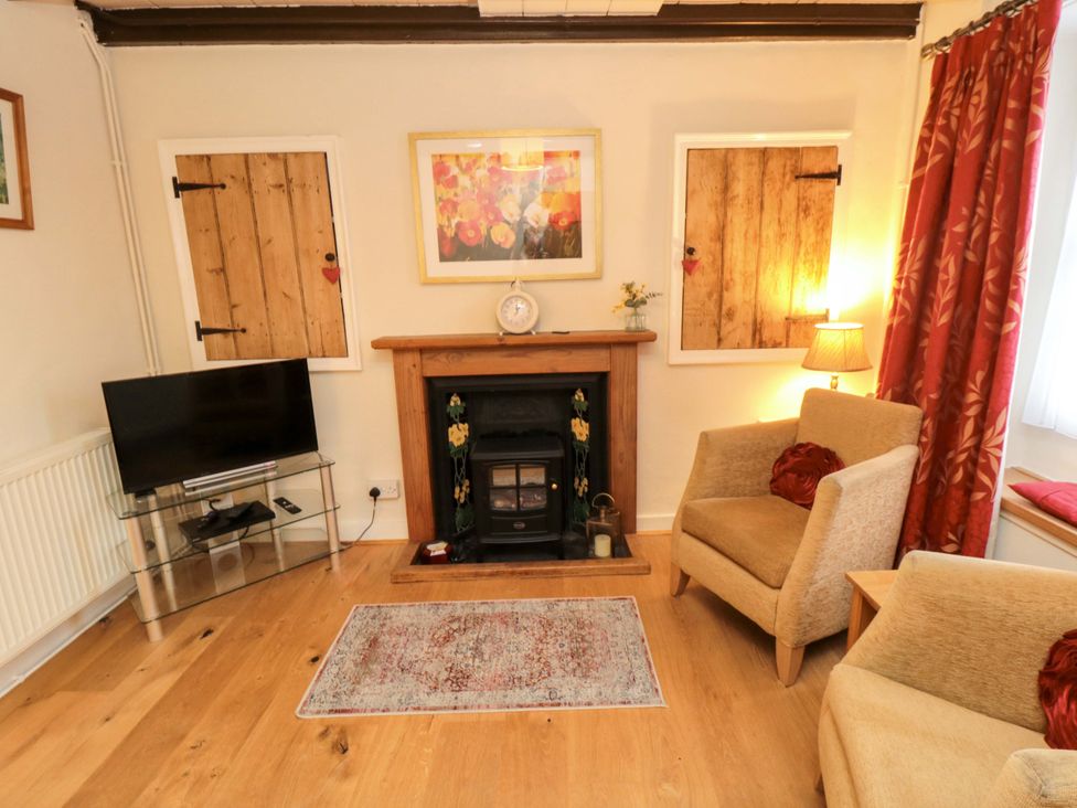 A living room with a fireplace and armchairs at Beacon Cottage in Pickering