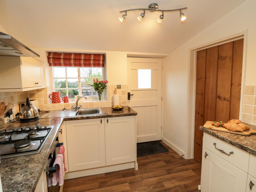 A kitchen with a sink and gas stove at Beacon Cottage in Pickering