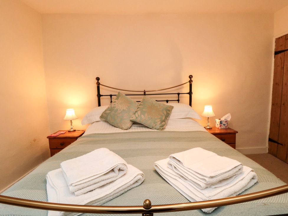 A bedroom with a bed and bedside table at Beacon Cottage in Pickering