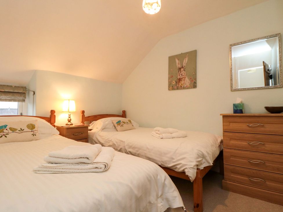 A bedroom with two beds and a lamp at Beacon Cottage in Pickering