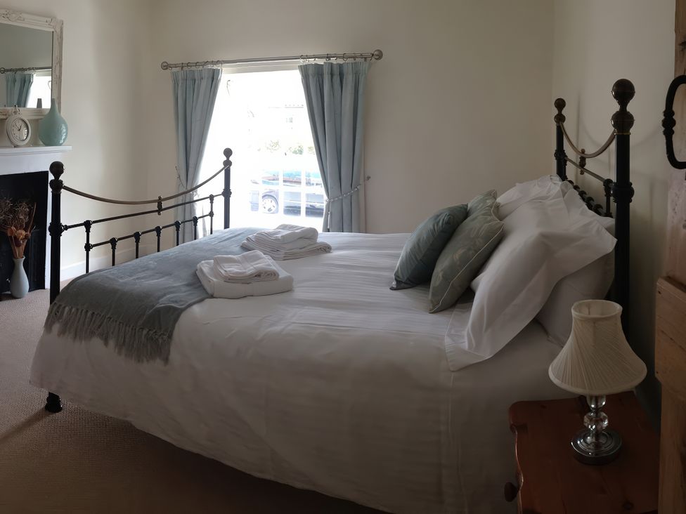 A bedroom with a bed and a vase on a mantel at Beacon Cottage in Pickering