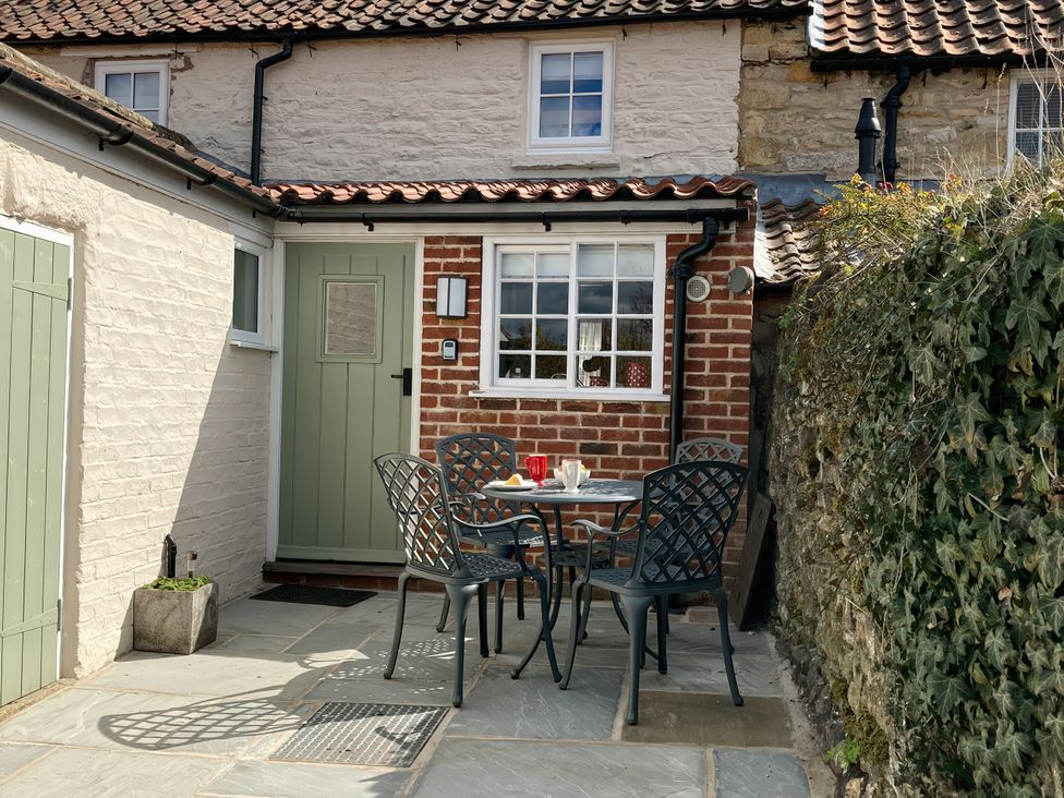 An outdoor seating area with a table and chairs at Beacon Cottage in Pickering