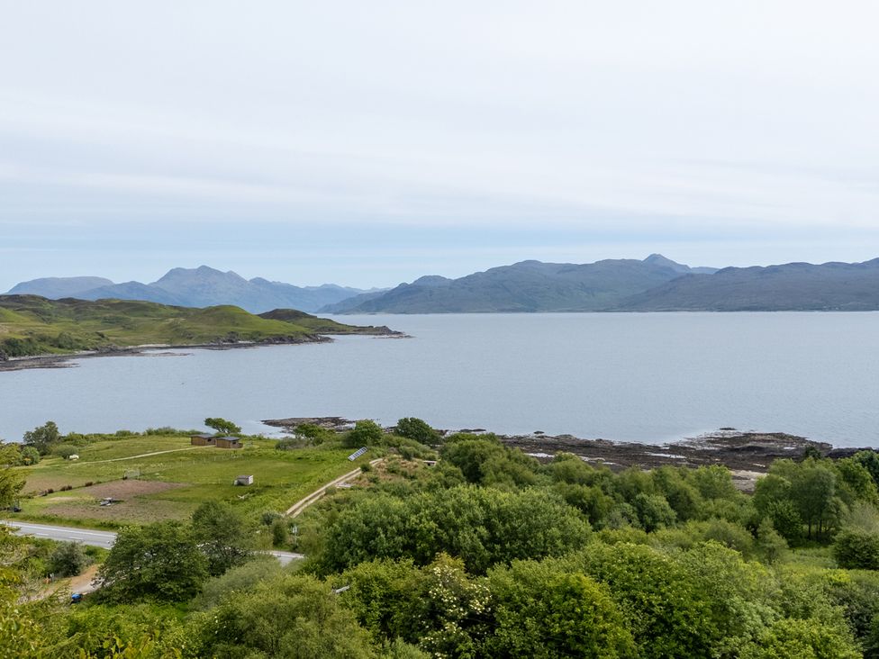A coastal landscape with green hills water and mountains in the background at The Lookout in Saasaig near Broadford