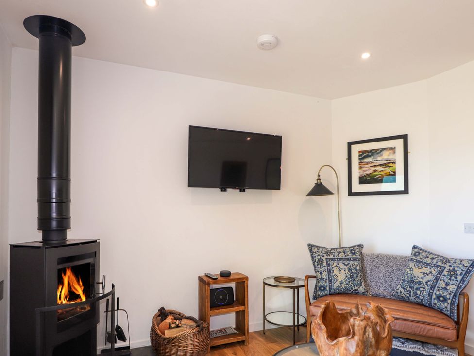 A living room featuring a wood stove and a sofa at The Lookout in Saasaig near Broadford