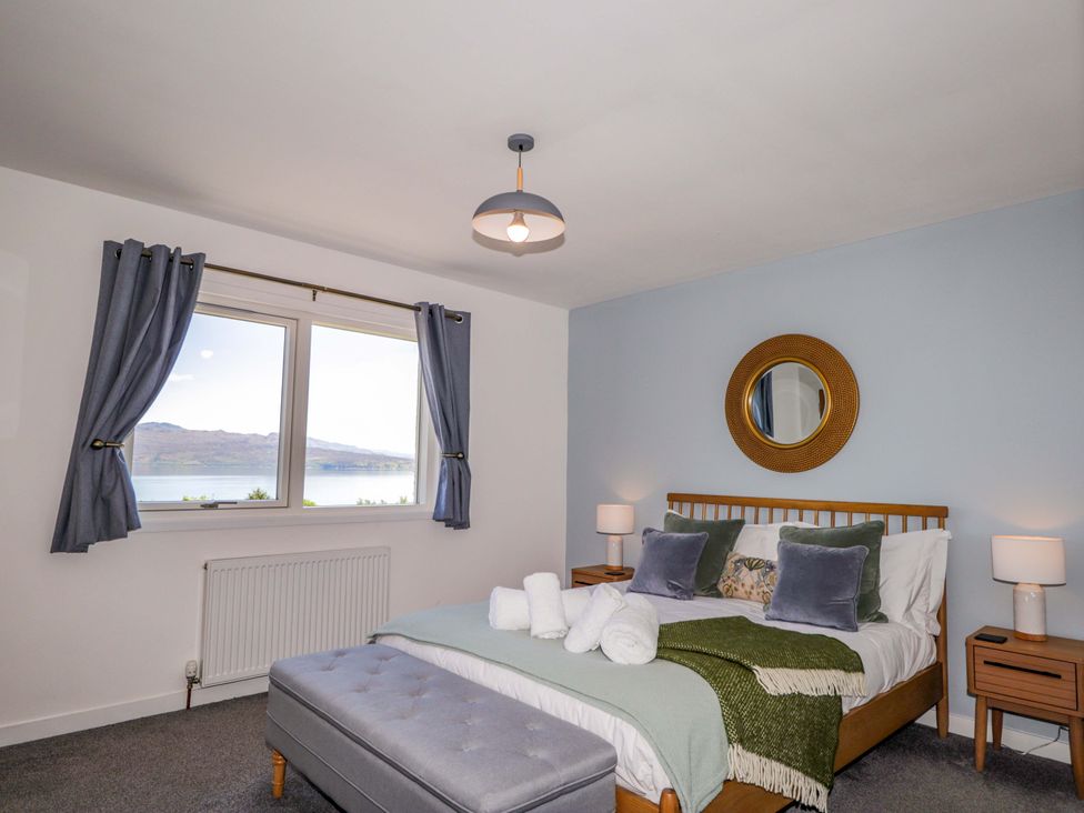 A bedroom with a bed and two bedside tables at The Lookout in Saasaig near Broadford