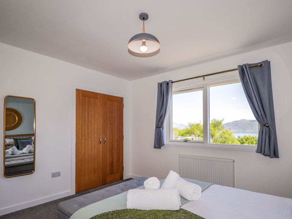 A bedroom with a bed and wardrobe at The Lookout in Saasaig near Broadford