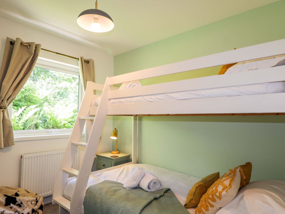 A bedroom with a bunk bed and a single bed at The Lookout in Saasaig near Broadford
