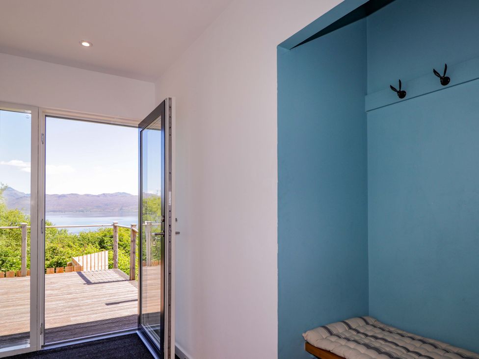 A hallway with double doors opening to a deck at The Lookout Saasaig near Broadford
