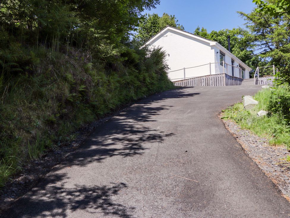 A house on a sloped driveway with trees and grass at The Lookout in Saasaig near Broadford