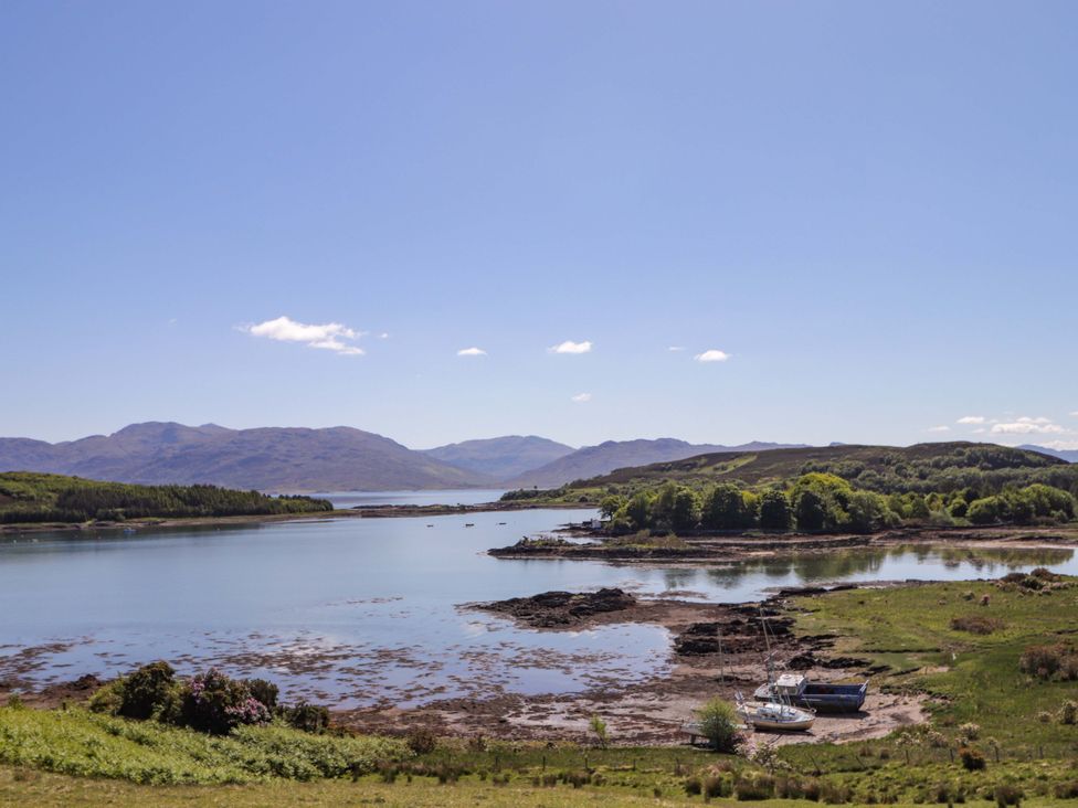 A view of the water and mountains with a boat at The Lookout in Saasaig near Broadford