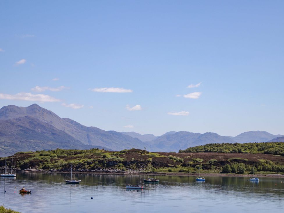 A landscape with boats on water and mountains in the background at The Lookout in Saasaig near Broadford