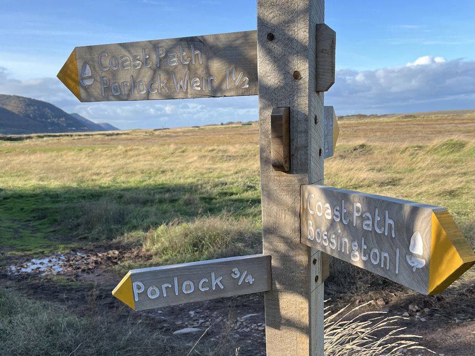 A signpost indicating distances to Porlock Weir and Bossington on the Coast Path in Porlock