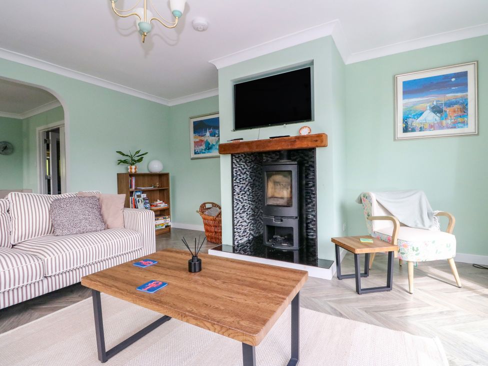 A living room with a fireplace and a television at Am Bruaich in Tayvallich