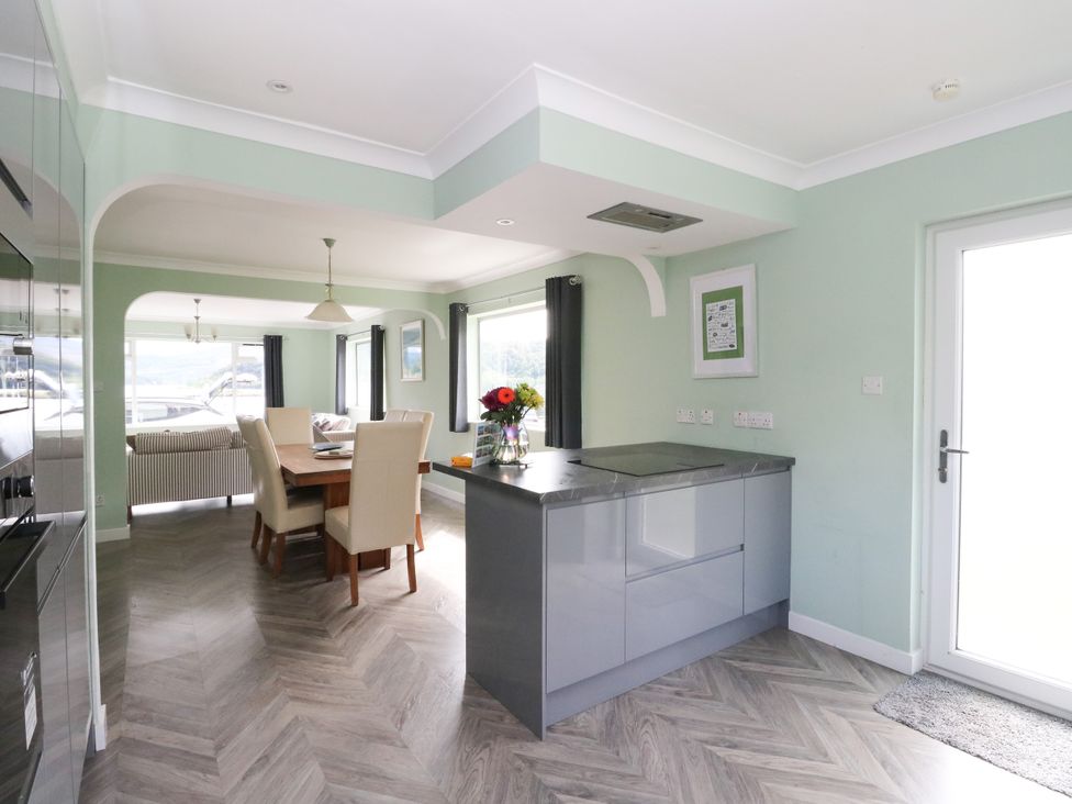 A kitchen with dining area and windows at Am Bruaich in Tayvallich