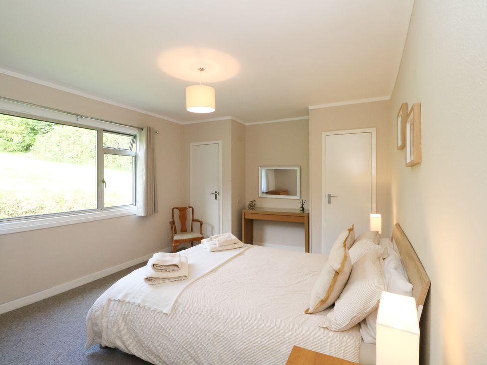 A bedroom with a bed and a table at Am Bruaich in Tayvallich