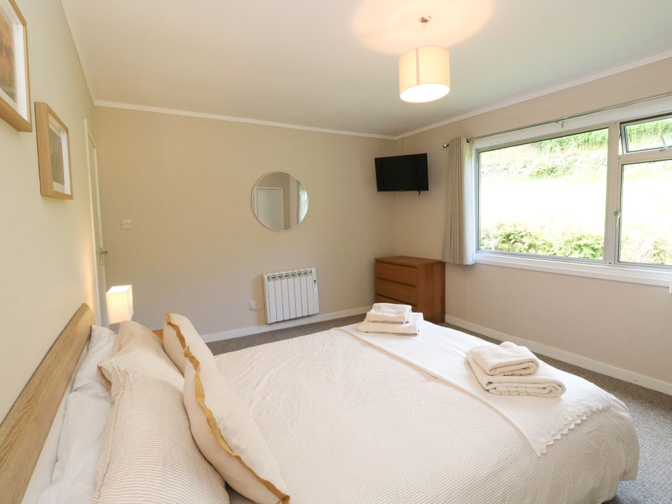 A bedroom with a bed and a television at Am Bruaich in Tayvallich