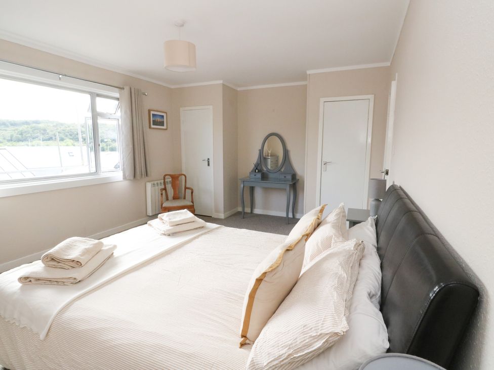 A bedroom with a bed and mirror at Am Bruaich in Tayvallich