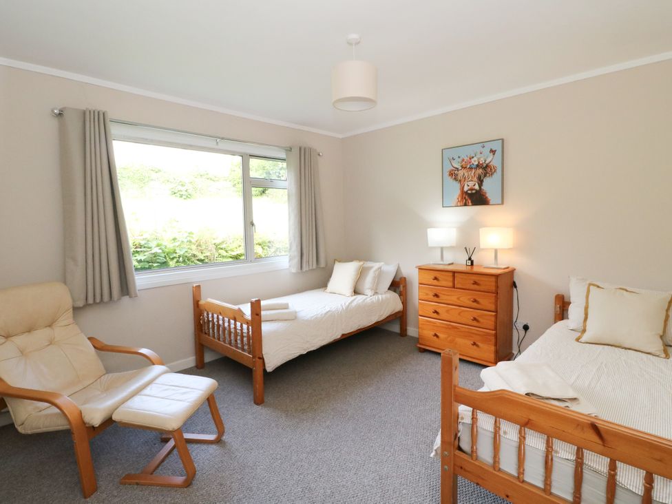 A bedroom with two beds and a dresser at Am Bruaich in Tayvallich