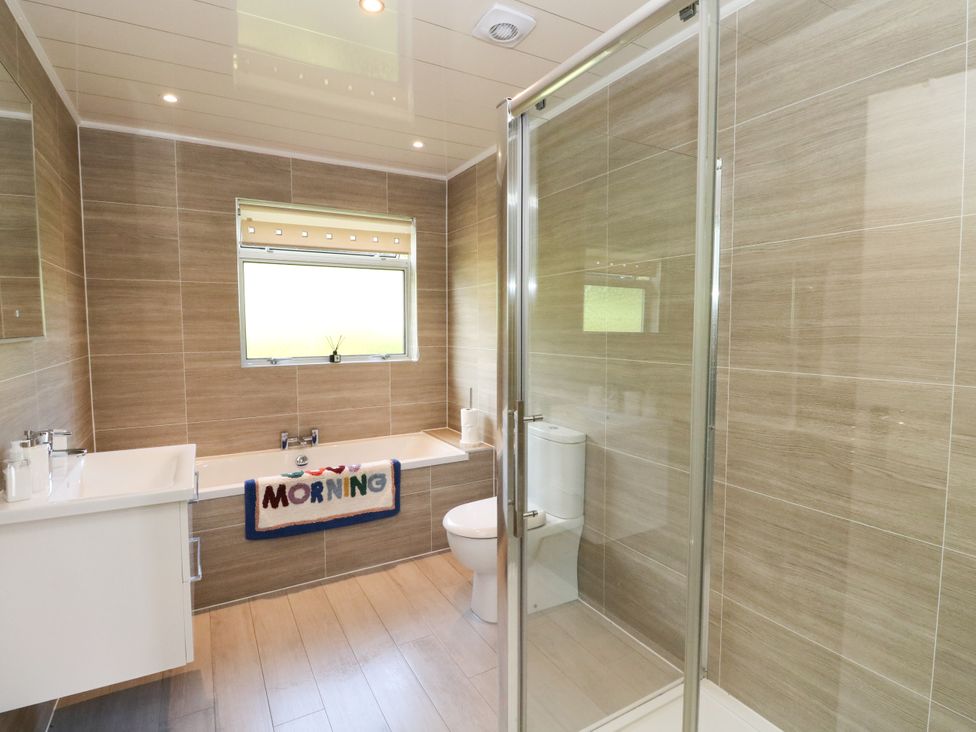 A bathroom with a bathtub, shower, and toilet at Am Bruaich in Tayvallich