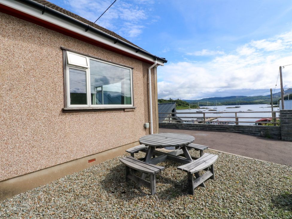 An outdoor area with a table and benches at Am Bruaich in Tayvallich