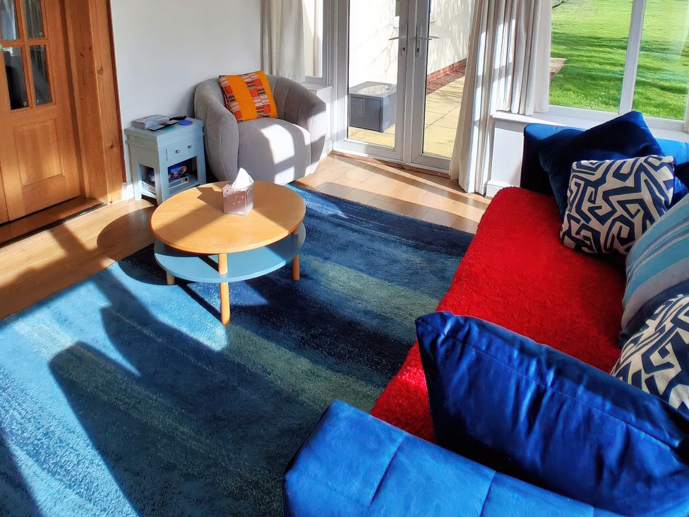 A living room with a coffee table and sofa at Buttercups at Midway, Kington