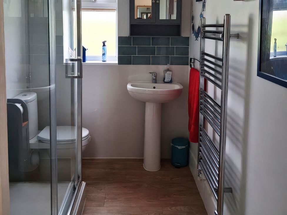 A bathroom with a shower, toilet, and sink at Buttercups at Midway in Kington