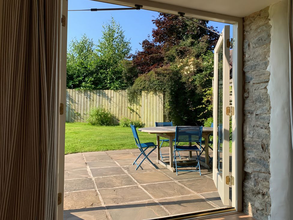 A garden view with a table and chairs at Brynlikky Cottage Chapel Lawn near Bucknell