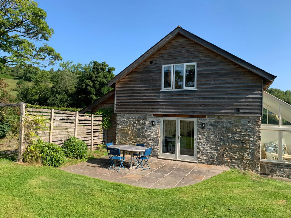 An outdoor area with a table and chairs at Brynlikky Cottage Chapel Lawn near Bucknell