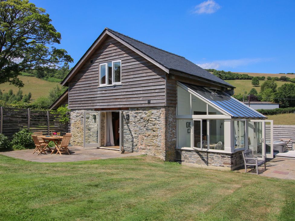 A house with a garden and seating area at Brynlikky Cottage Chapel Lawn near Bucknell