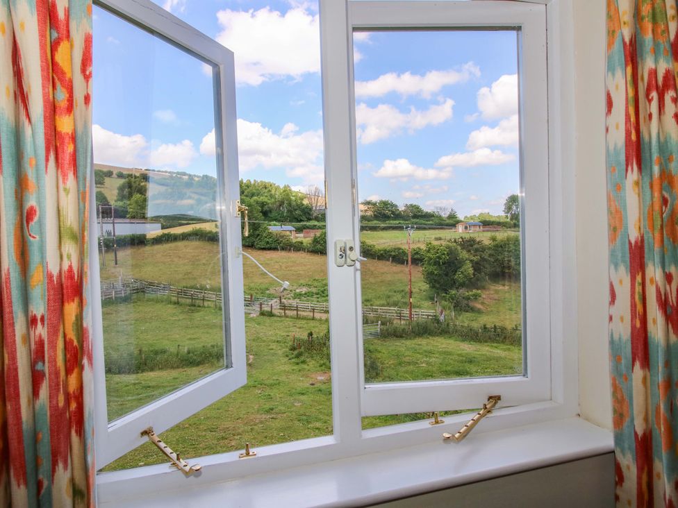 A window with a view of a field at Brynlikky Cottage Chapel Lawn near Bucknell
