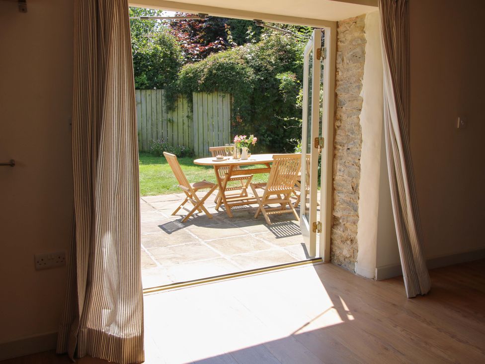 A dining room with an open door leading to the garden at Brynlikky Cottage Chapel Lawn near Bucknell