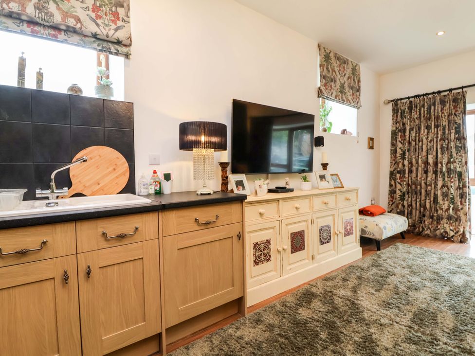 A kitchen with a sink and television at The Coach House, The Grove in Combe Martin