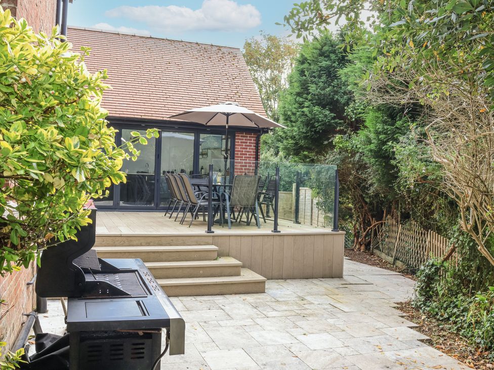 An outdoor seating area with a grill and dining furniture at 49 Ulwell Road Swanage