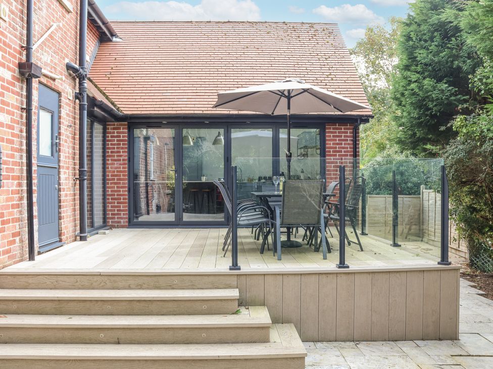 An outdoor area with a deck, table, and chairs at 49 Ulwell Road Swanage