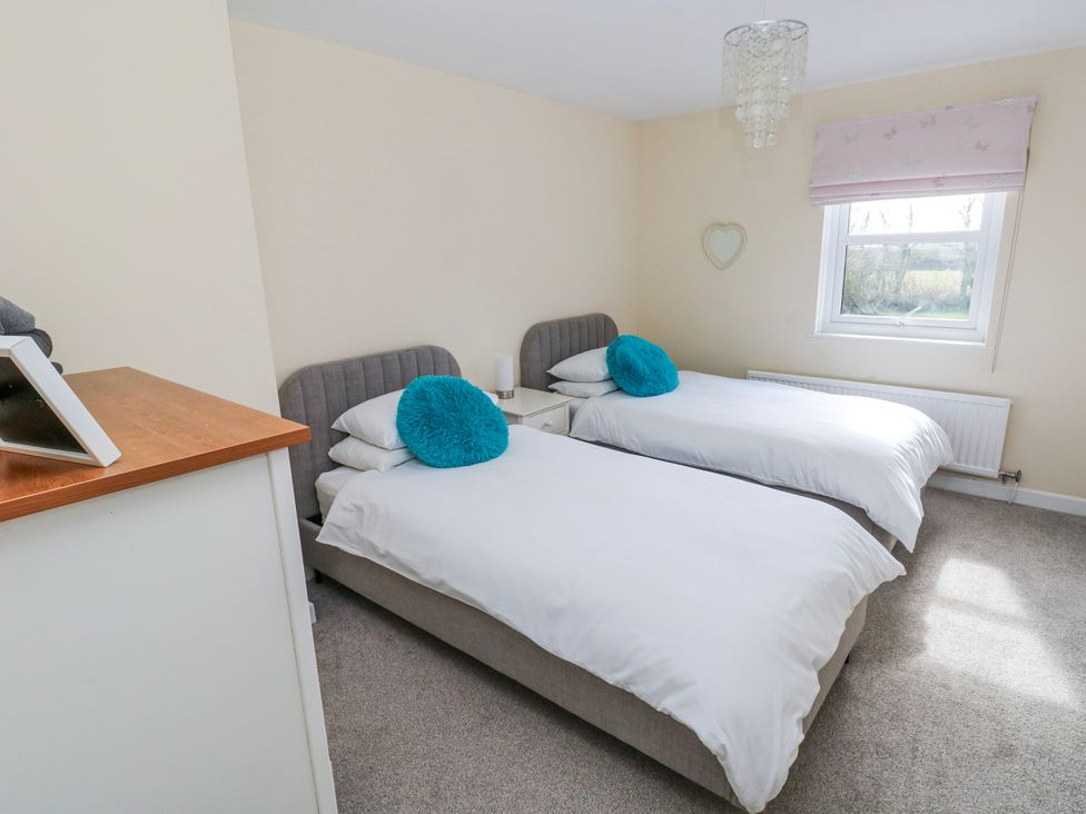 A bedroom with twin beds and a window at Mountain Farm in Broad Haven