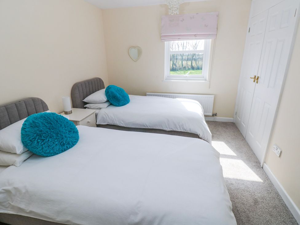 A bedroom with two beds and a window at Mountain Farm in Broad Haven