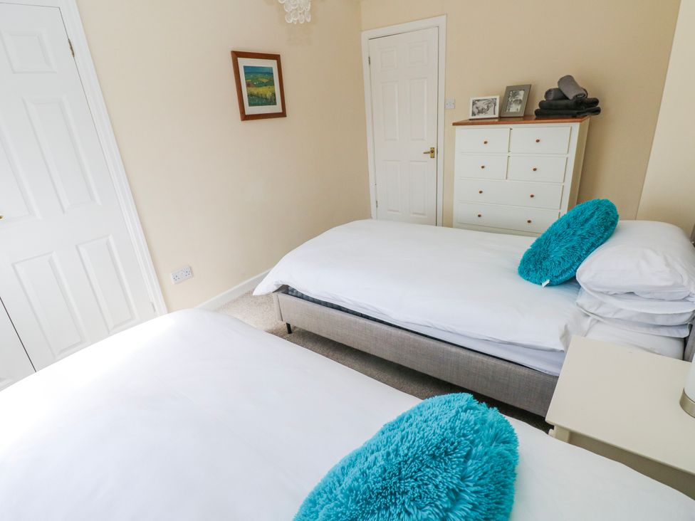 A bedroom with two beds and a dresser at Mountain Farm in Broad Haven