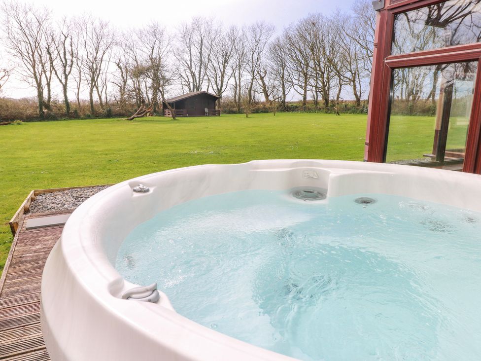 A hot tub with a view of the garden at Mountain Farm in Broad Haven