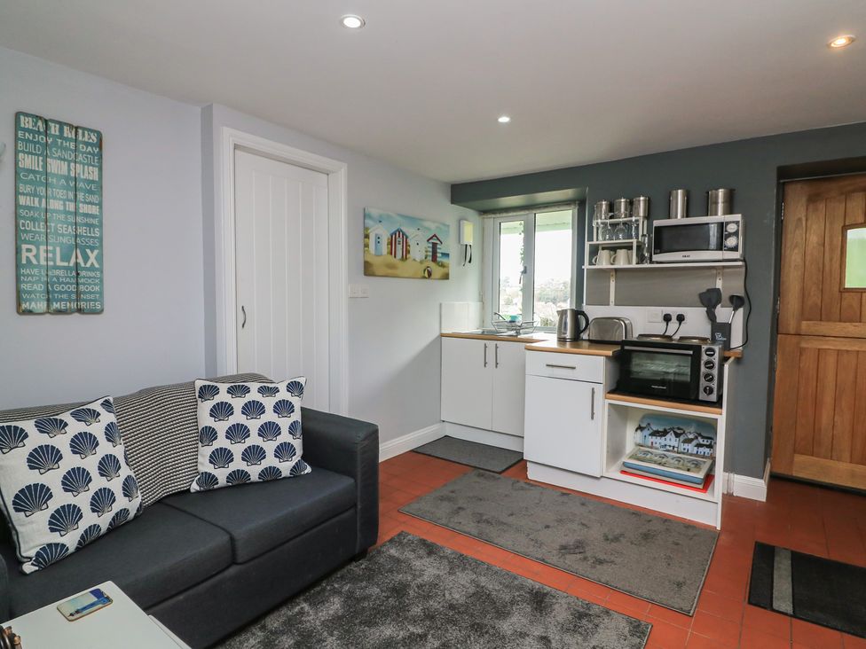 A kitchen with a sofa and wall art at Hidden Treasure in Brixham