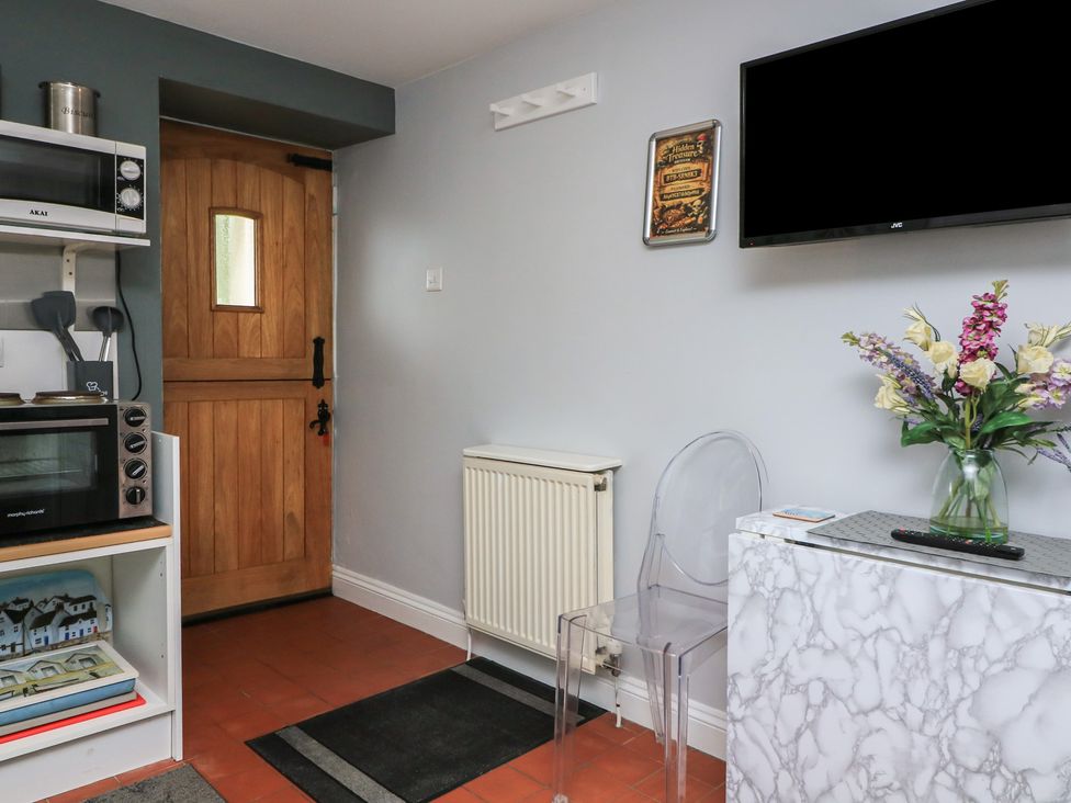 A kitchen with a door and microwave at Hidden Treasure Brixham
